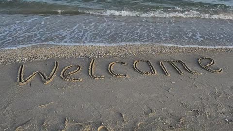 &quot;Welcome&quot; in the sand at the seashore