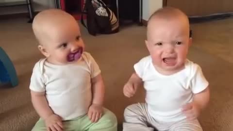 Twin baby girls fight over pacifier