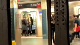 A man with red sweater wrapped around waist dances out of subway