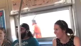 Guy orange shirt climbs between stalled not moving subway trains walks off