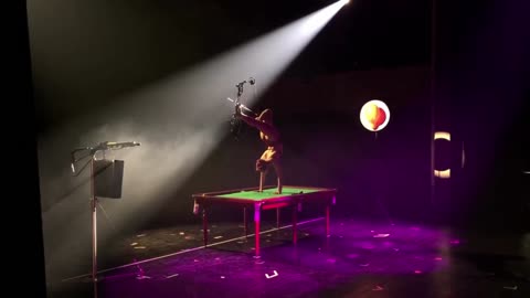 Performer Executes Spectacular Bow and Arrow Trickshot During On-Stage Handstand Using Her Legs