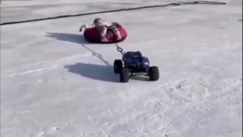 RC Car Draging A Kid In Snow Field