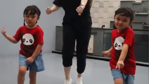 The mother and her twins dance very compactly