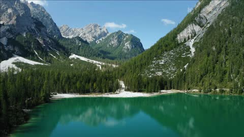 aerial footage over lake braies pragser wildsee and mountains in the background