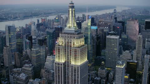 The empire state building and city glow at dusk