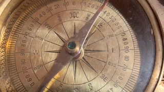 An old compass points the needle towards the North Pole