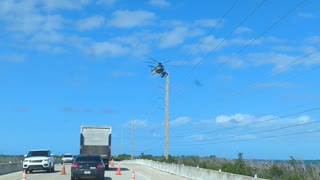 Linesman Balancing on Helicopter for Work