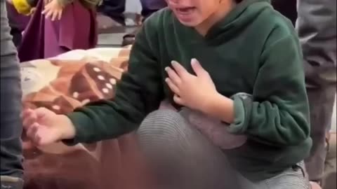 A little girl bids farewell to her little brother in Gaza