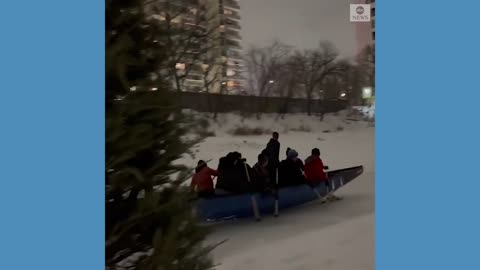 Rowers cruise down frozen river in Winnipeg.