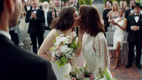 Picture of two LGBT females lesbians ladies kissing during wedding service