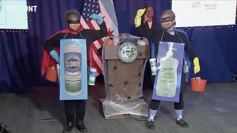 Chicago Mayor Lori Lightfoot enters a news conference dressed as “Corona Destroyer”