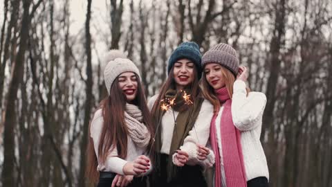 Three Women Holding Sparklers Outdoors