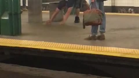 Man in black shirt does yoga stretches in subway station