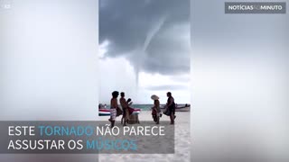 Músicos tocam durante tornado em praia