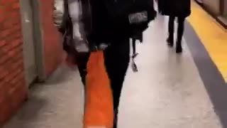 Woman walking in subway station wears big orange fox tail and ears