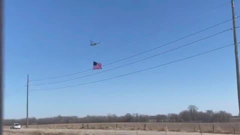 Helicopter with a massive flag accompanying US convoy for freedom en route to Washington