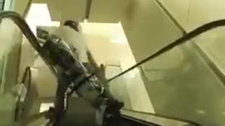 Guy riding bike down escalator second angle