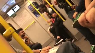 Man on train rapping into orange container