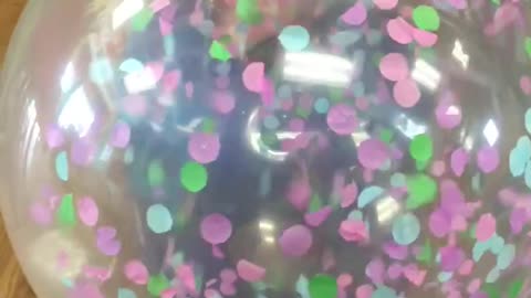 Slow motion balloon being filled with confetti