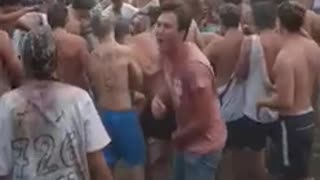 Shirtless guy carried by crowd falls down