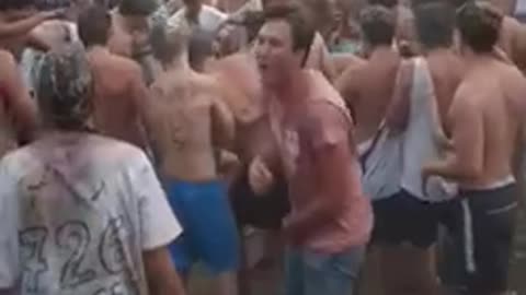 Shirtless guy carried by crowd falls down