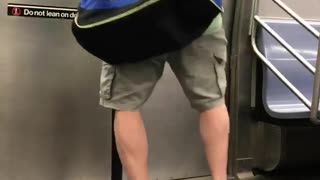 Bald guy green shirt dancing in front of subway door exit