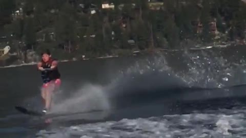 Guy in pink swim shorts fall from water skiing