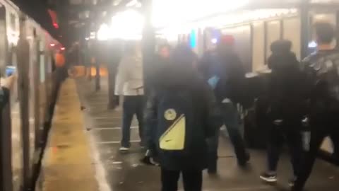 Man wearing trashbag gets pinned up to wall in subway fight