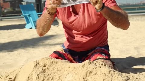 a man digging money from the sand 😂