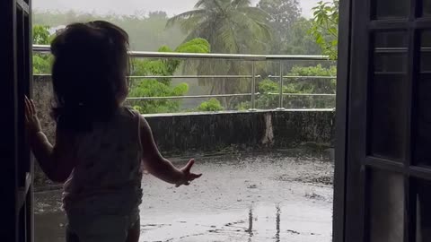 Cute baby loves to see the rain in a beautiful evening