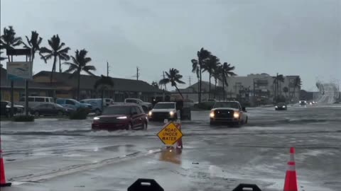 Vehicles struggle to pass through submerged streets as Storm Debby hits Florida