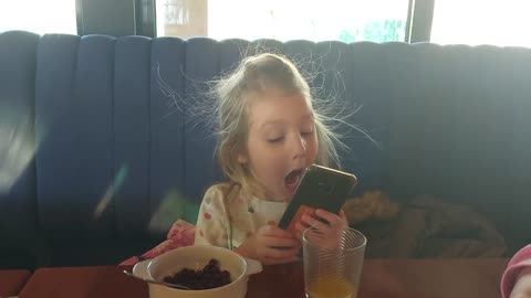 Cute toddler girl making selfies in a funny way