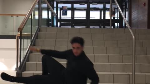 Guy in black sweater slides down stairs