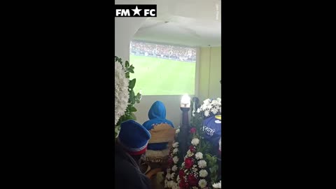 Moment mourners watch Copa America match next to an OPEN COFFIN