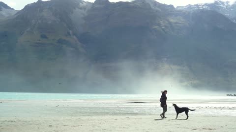 Woman with dog near mountains