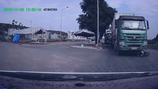 Man Crashes Motorcycle and Narrowly Escapes Moving Truck