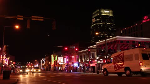 Cars passing Fast In Night Day By Hilton Hotel