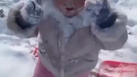 A cute little boy playing with snow ...