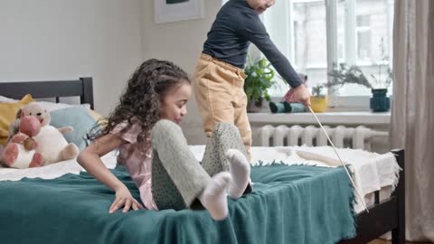 kids petting their cats on the bed room funn