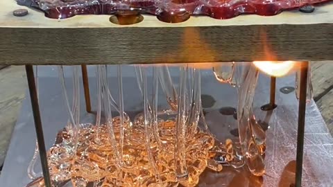 Dripping Molten Glass Over a Wooden Board With Holes