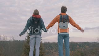 Young Male And Female Hikers With Backpack Spreading Arms And Enjoying Freedom In Nature
