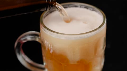 Filling a mug with beer on a dark background