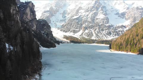 frozen lake lago di braies surrounded by forest and rocky mountains dolomites italy