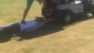 Music guy in green shorts pours beer while friend holds on to golf cart