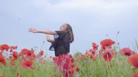 Girl dancing happily in a field of flowers