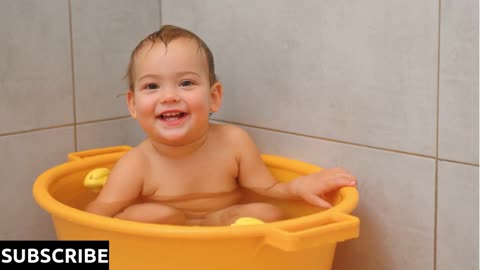 Slow motion video of adorable baby girl sitting and smiling at bath