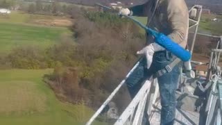 Man Shows How He Paints a Tall Tower for Work