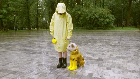 A woman and a dog wearing Raincoat and Rubber Boots