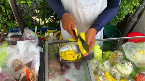 Thai street fruit stall, let a person dazzling knife skills!