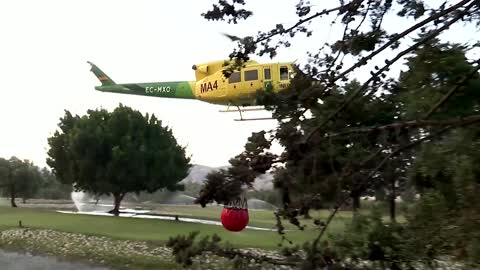 Helicopters use water from golf course to battle wildfire in Spain